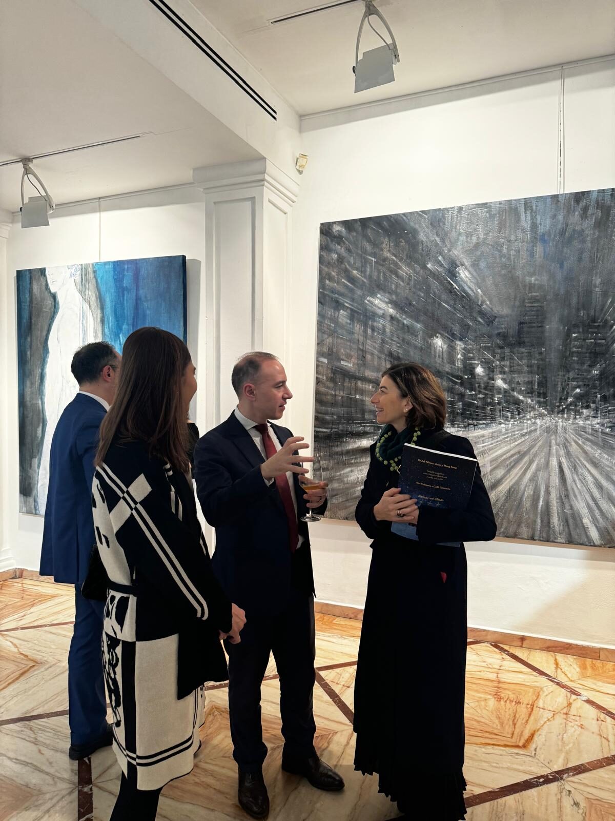 Marco Cioffi, founder de Neuram, conversando con asistentes en una galería de arte durante un evento cultural en España.